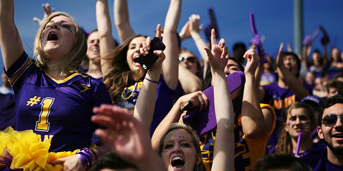 Fans cheering at laurier stadium in purple and gold attire